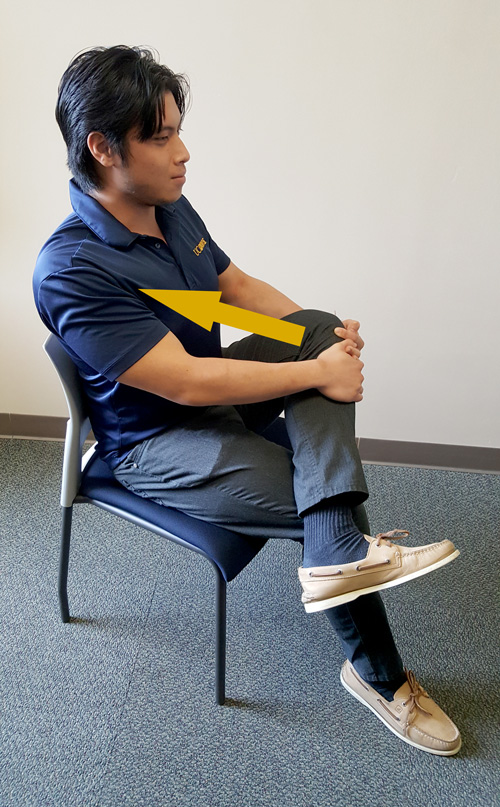 Student demonstrating seated piriformis stretch.