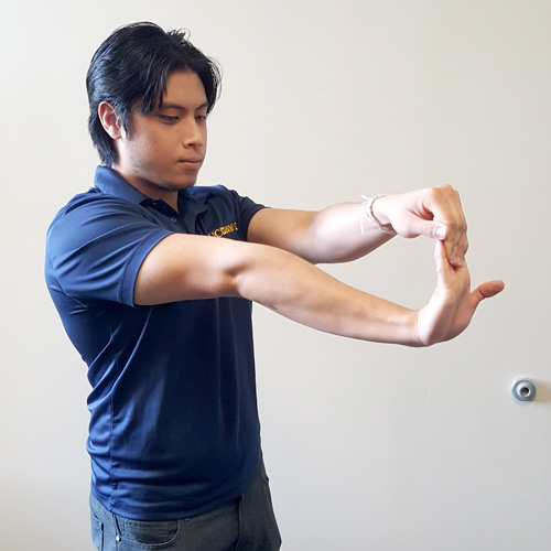 Student demonstrating wrist flexor stretch.