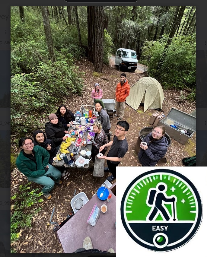 Several campers enjoying a big delicious meal together in the woods