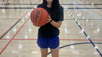 This photo shows the winner of the 3 point competition holding a basketball.