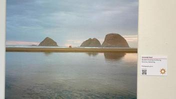 Beach scene with distant horizon and minute figures in the center