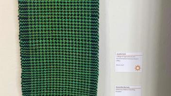 scarf woven in green and black with a hounds tooth pattern