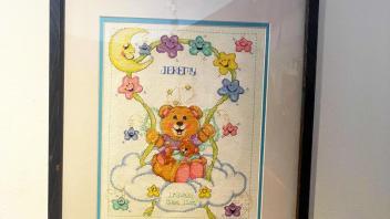 cross stitch featuring a teddy bear with a ribbon of stars and a moon for a child