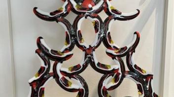 fused glass sculpture of black red and white arches stacked into a tower