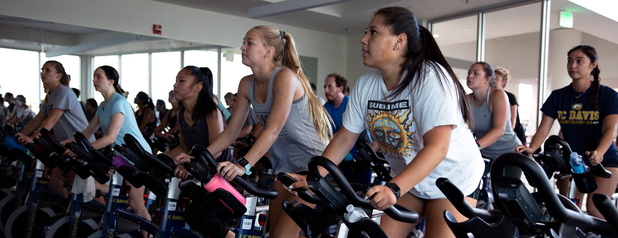 People riding stationary bikes in an indoor cycling studio