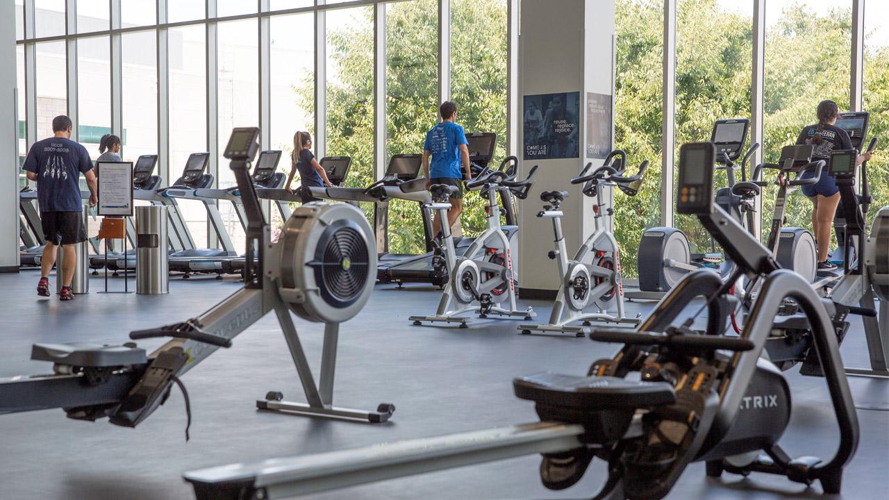 People using various exercise equipment in a gym