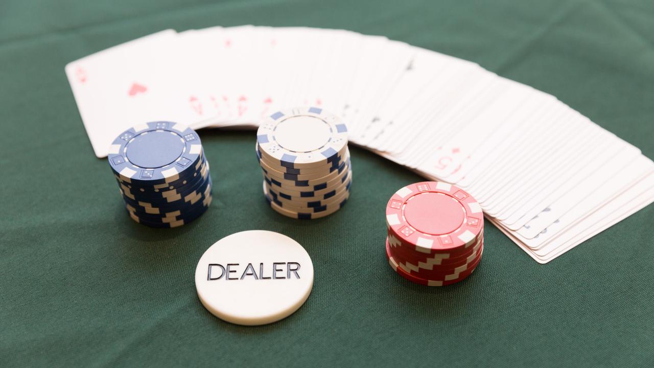 Picture of poker chips, cards, and dealer button on poker table