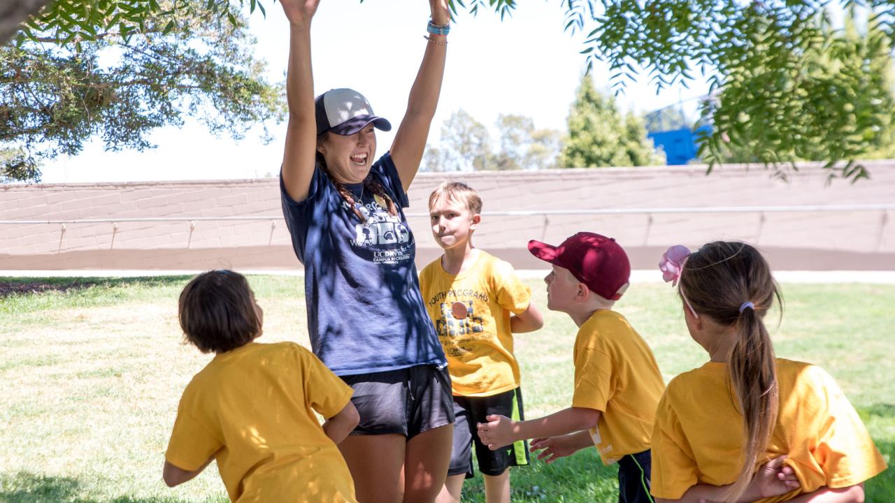 Camp counselor playing outside with kids