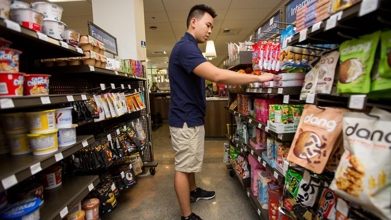 A student looks at food items for sale in the market.
