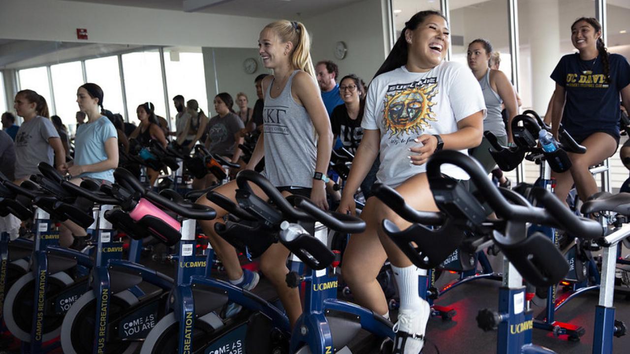 A group of people riding indoor spin bikes.