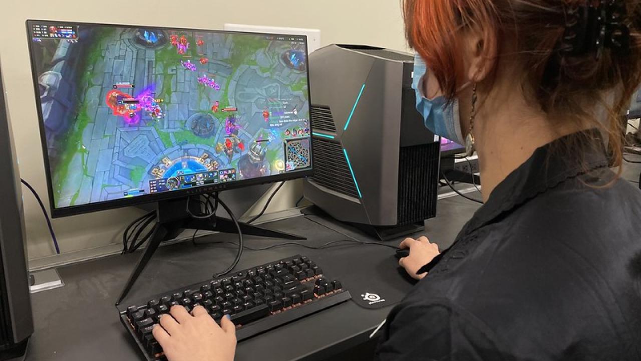 Woman playing League of Legends on a computer