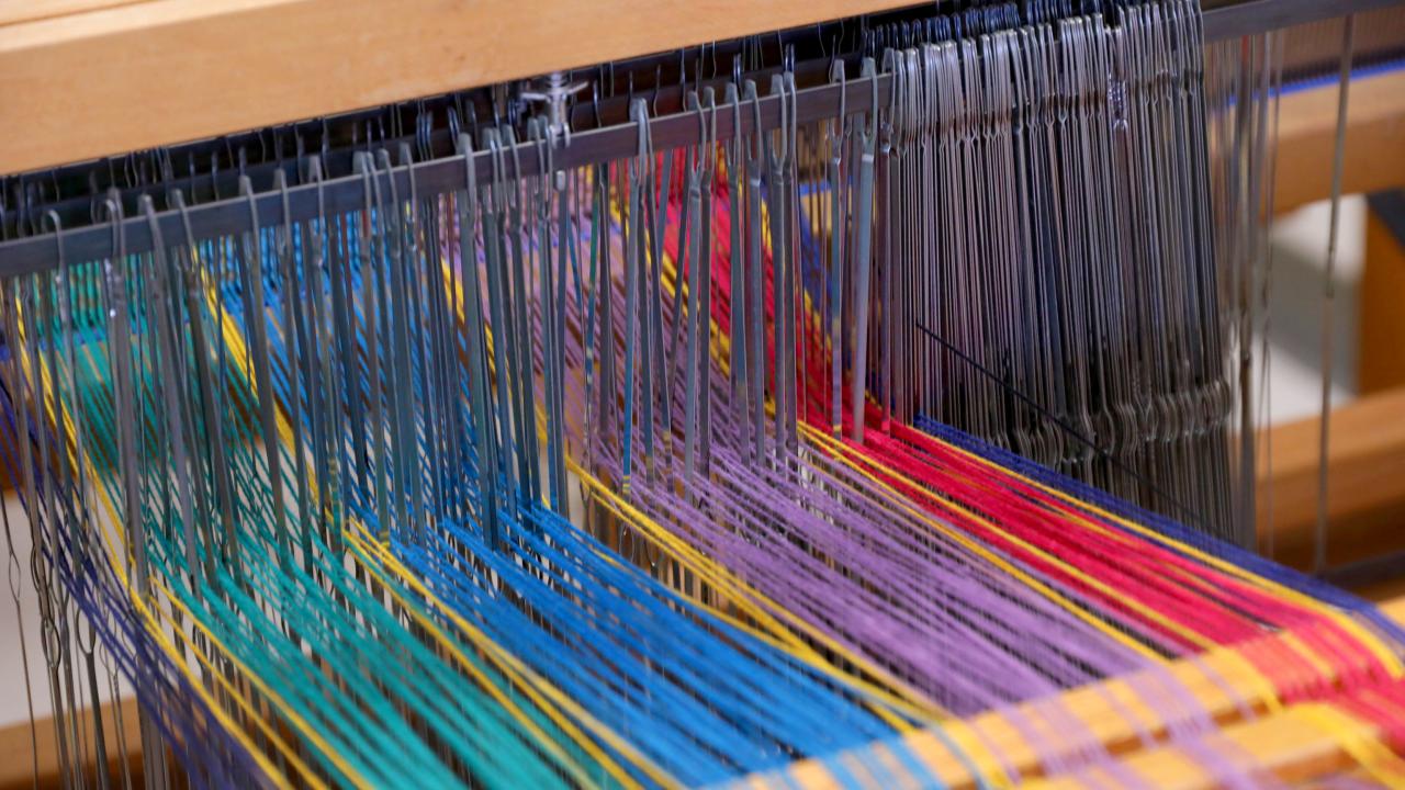 Multicolored string on a wooden loom
