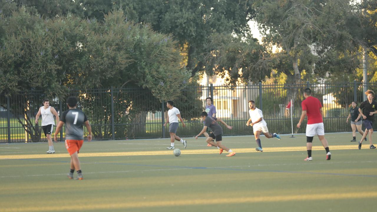 9 players playing soccer at UC Davis Dairy Field