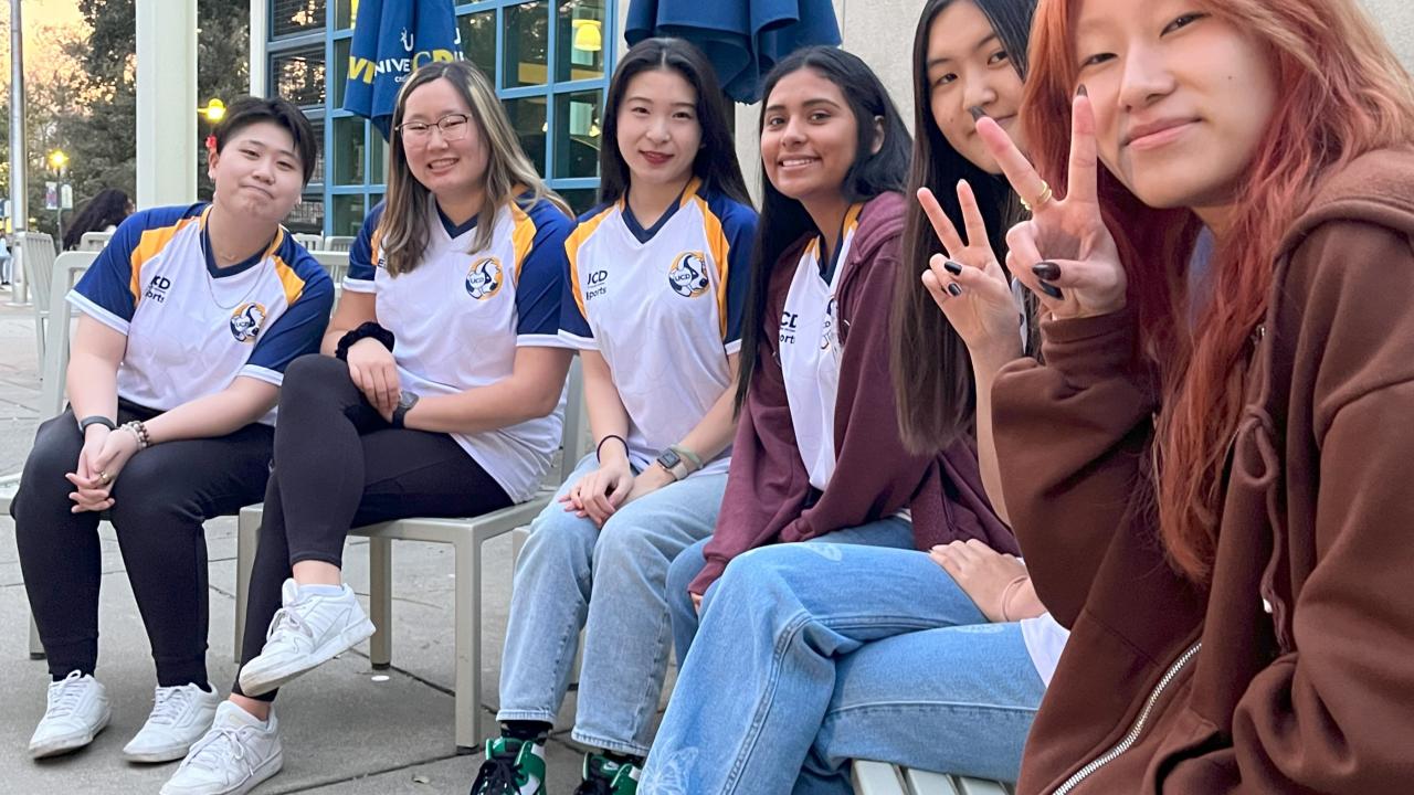 photo of 6 students sitting on benches in front of the Memorial Union