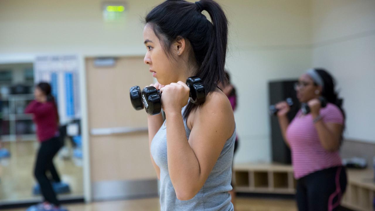 People lfting hand weights during a group exercise class