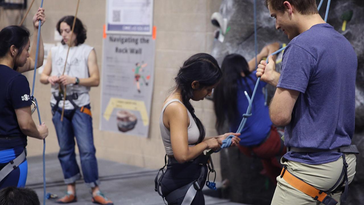Students tying into their harnesses at the ARC Rock Wall