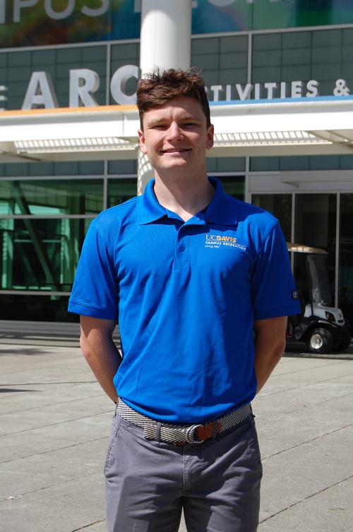 Pierce Desmond wears a blue shirt and smiles outside of the Activities and Recreation Center