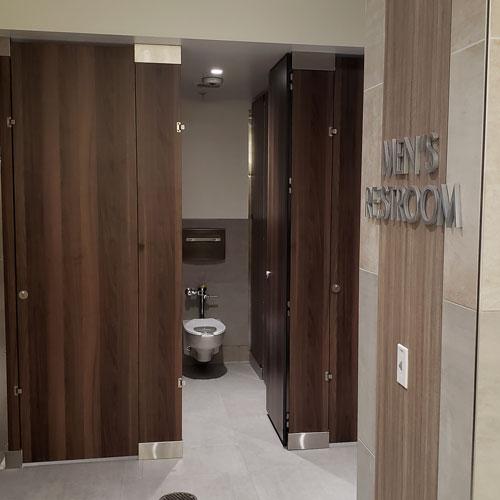 Men's restroom shown with one door open
