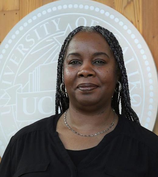 Headshot of Andrea in front of the UC Davis seal