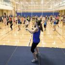 An instructor leading a large group of Zumba dancers.