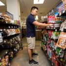 A student looks at food items for sale in the market.