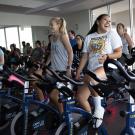 A group of people riding indoor spin bikes. 