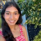 Neeraja stands next to a tree and smiles for the camera.