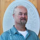 Headshot of Zach in front of the UC Davis seal
