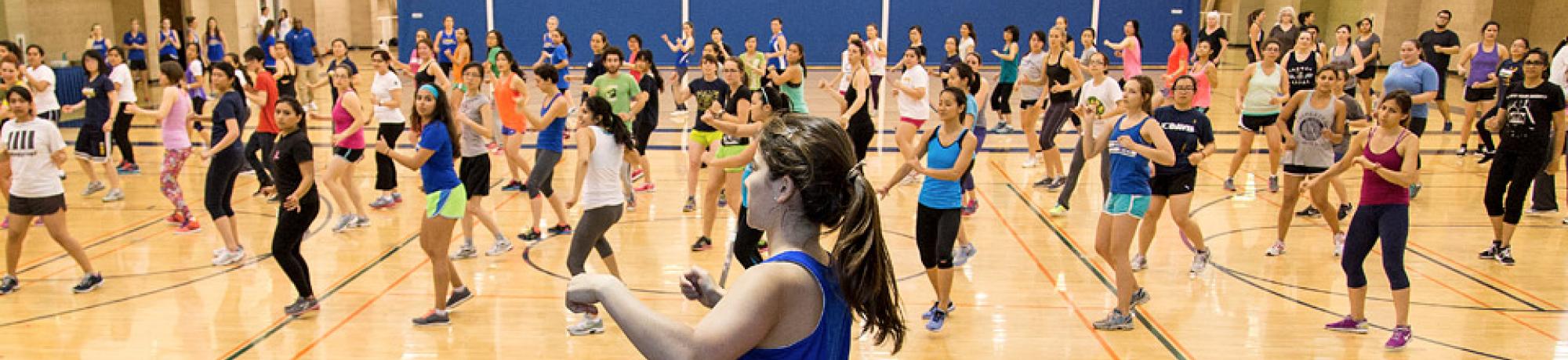 a classroom of people doing Zumba together