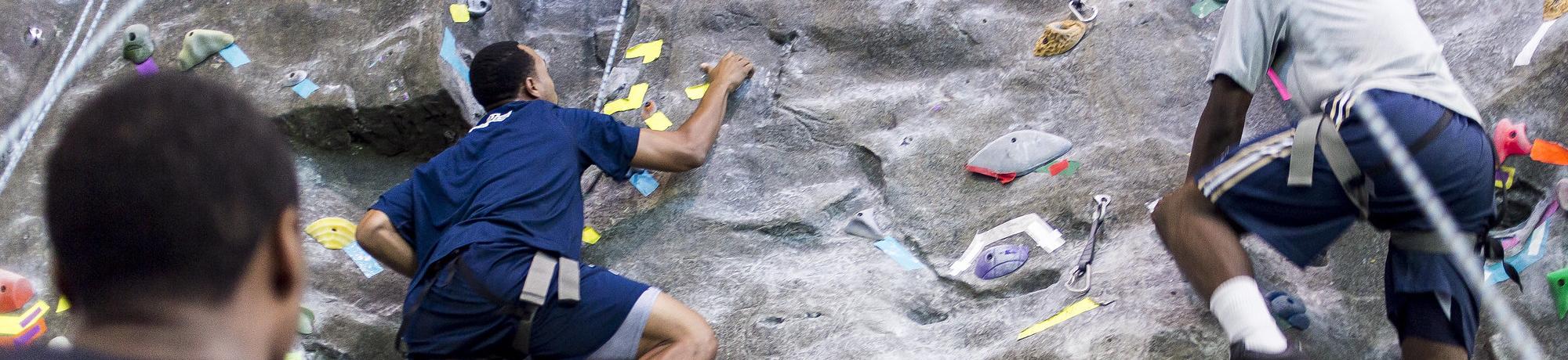 People climbing up the indoor rock wall