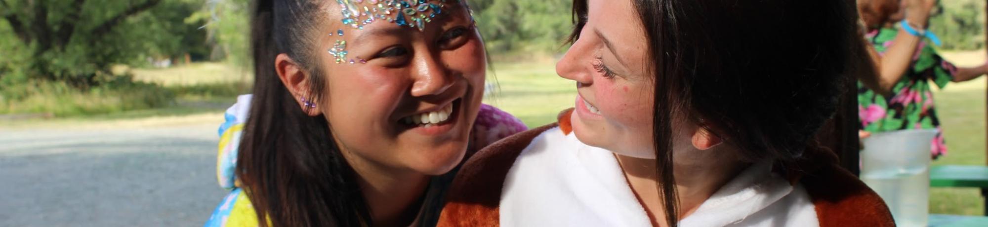 Cal Aggie Camp counselors smiling at each other